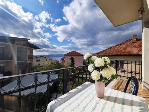 a vase of flowers sitting on a table on a balcony at Apartments Picioski in Peštani