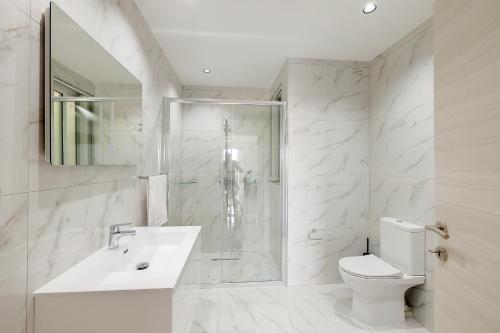 ein Bad mit einem WC, einem Waschbecken und einer Dusche in der Unterkunft Deluxe 2BR Apartment in central St Julians in St Julian's