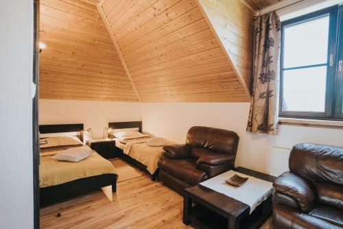 Pokój z 2 łóżkami, kanapą i krzesłem w obiekcie Grzechowisko w Wetlinie