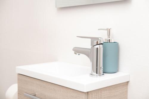 a bathroom sink with a blue soap dispenser on it at Global Properties, Bonito apartamento en Urbanizacion Ciudad Mar in Puerto de Sagunto