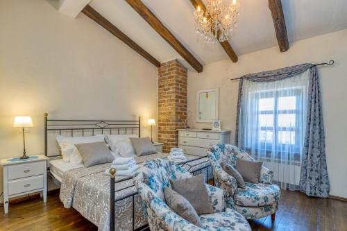 Un dormitorio con una cama y dos sillas y una ventana. en Villa Santolina, en Baderna