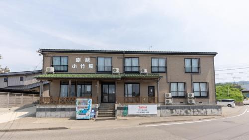 a building with a sign in front of it at Tabist Odakeya Ryokan Kashiwazaki in Kashiwazaki