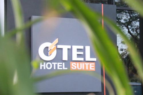 un panneau indiquant une suite d'hôtel est vu à travers une usine dans l'établissement OTEL Hotel Suite, à Sibu