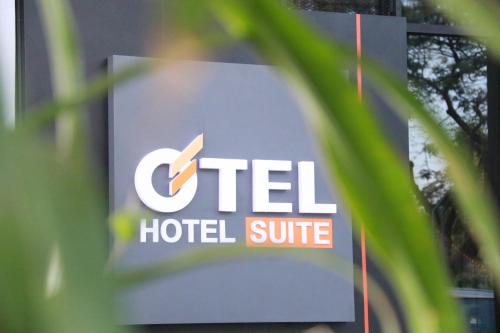 a sign for a hotel suite is seen through a plant at OTEL Hotel Suite in Sibu