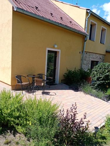 a patio with a table and chairs in front of a house at Ralsko-Hradcany - apartmán in Hradčany
