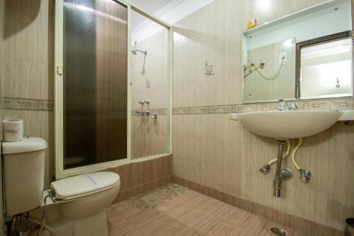 a bathroom with a toilet and a sink and a shower at Hotel Grand Park Inn in New Delhi