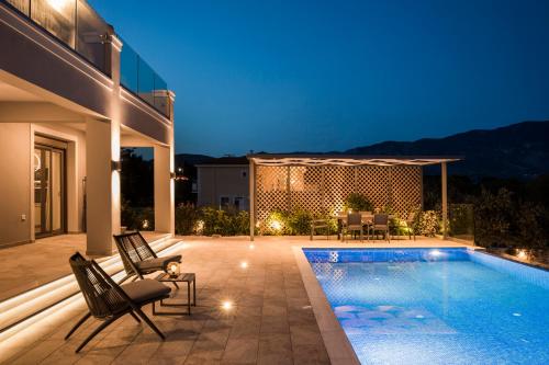 a villa with a swimming pool at night at Anthélia villa in Kefallonia