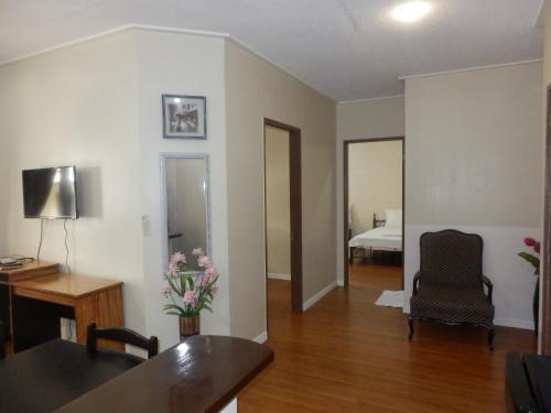 1 dormitorio y sala de estar con escritorio. en Casa Saudade Condotels and Transient Rooms en Olongapo