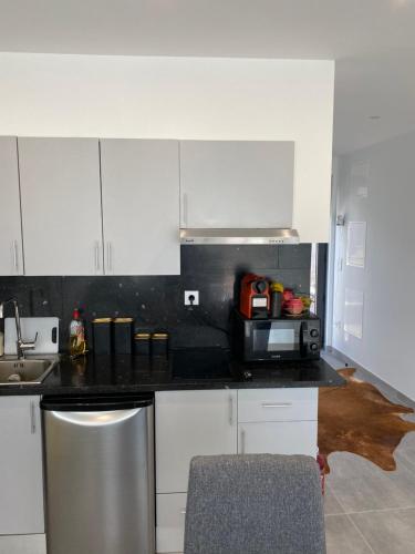 een keuken met witte kasten en een zwart aanrechtblad bij Douro Box in Castelo de Paiva
