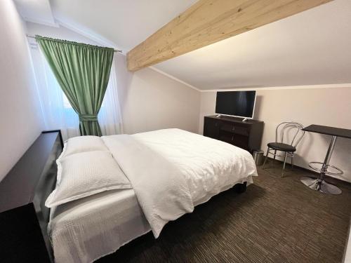 - une chambre avec un lit blanc et un rideau vert dans l'établissement PENSIUNEA DIANA SKI, à Statjunea Borsa