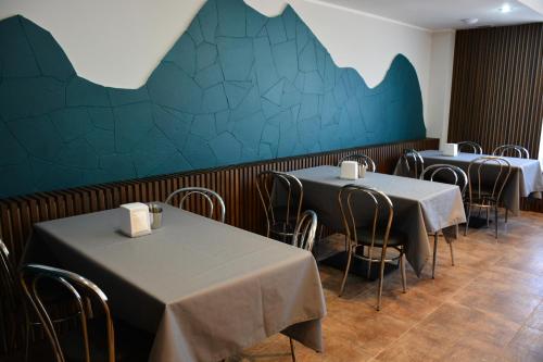 a dining room with two tables and a blue wall at PENSIUNEA DIANA SKI in Borşa