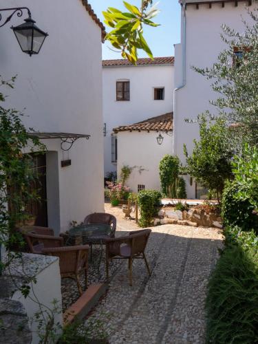 a courtyard with a table and chairs in a building at Alojamientos Biarritz VISTA JARDÍN in Fuenteheridos
