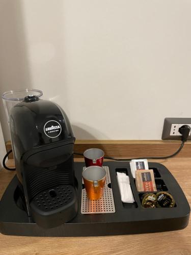a black coffee maker with a cup on a tray at Casa Vacanze SANGALLO in Nettuno