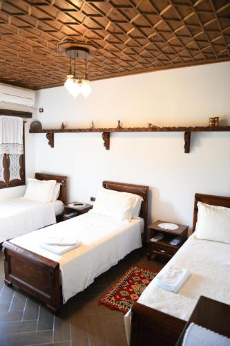 a bedroom with two beds and a chandelier at Hotel Kaceli in Berat