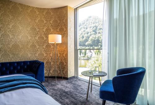 a hotel room with a bed and a large window at Emser ThermenHotel in Bad Ems
