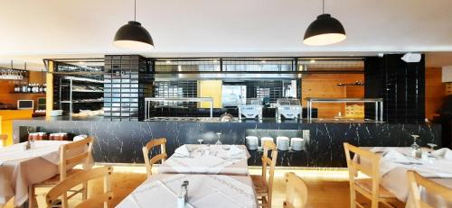 a restaurant with white tables and chairs and a counter at Atlantis Boutique City Hotel in Rhodes Town