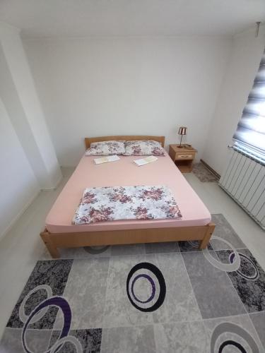 a bedroom with a pink bed and a rug at Apartment Maida in Dubrave Gornje