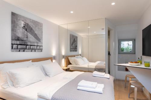 Cet appartement comprend une chambre avec un grand lit blanc et une cuisine. dans l'établissement Old Town Apartments u nikse, à Dubrovnik