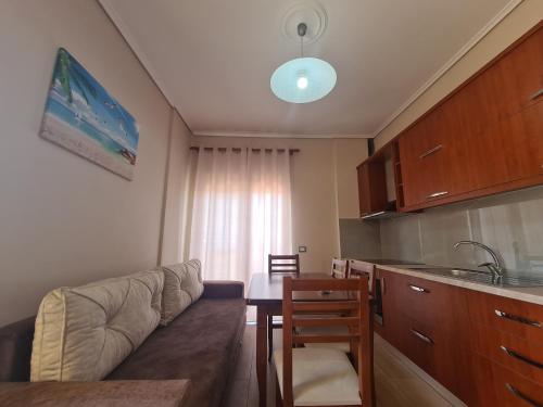 un soggiorno con un divano e un tavolo e una cucina di Welcome home a Sarandë