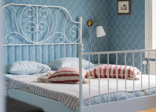 a bedroom with a white bed with pillows and a lamp at Villa Ekbladh in Västanfjärd