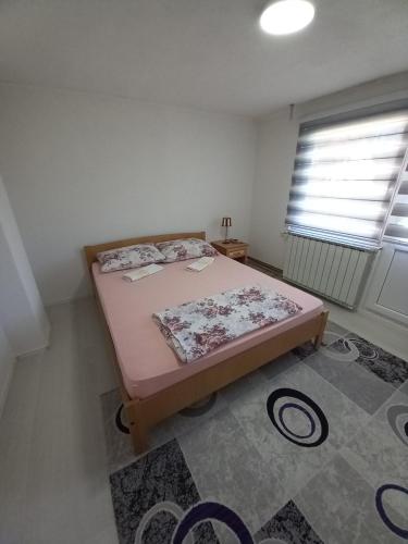 a bedroom with a bed in a room with a window at Apartment Maida in Dubrave Gornje