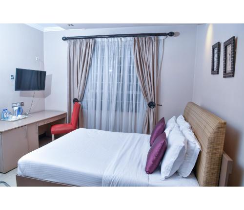 a hotel room with a bed with purple pillows at Hillpark Hotel in Nairobi