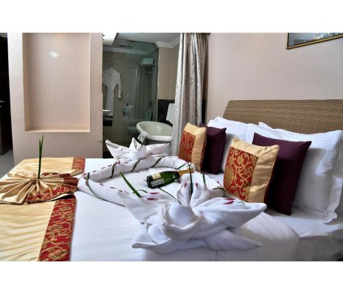 a hotel room with a bed with white sheets and pillows at Hillpark Hotel in Nairobi