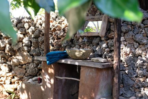 a bowl sitting on a table next to a wall at Rumah Pampa at Pachamama in Nembrala