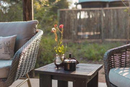 a wooden table with a vase of flowers on it at Umkumbe Bush Lodge - Luxury Tented Camp in Sabi Sand Game Reserve