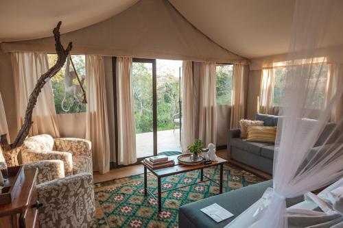 サビ・サンド動物保護区にあるUmkumbe Bush Lodge - Luxury Tented Campのソファとテーブルのあるリビングルーム