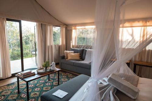 a living room with a couch and a table at Umkumbe Bush Lodge - Luxury Tented Camp in Sabi Sand Game Reserve