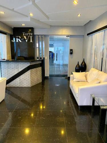 a living room with a white couch and a table at Casa HJP - Rooftop Pool, Gym, Balconies, in Santo Domingo