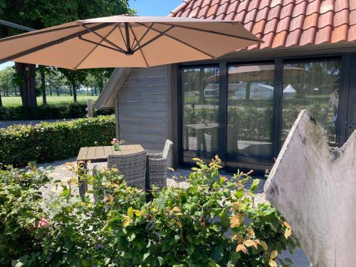 a table and an umbrella in front of a house at BNB DREAMS in Vorstenbosch