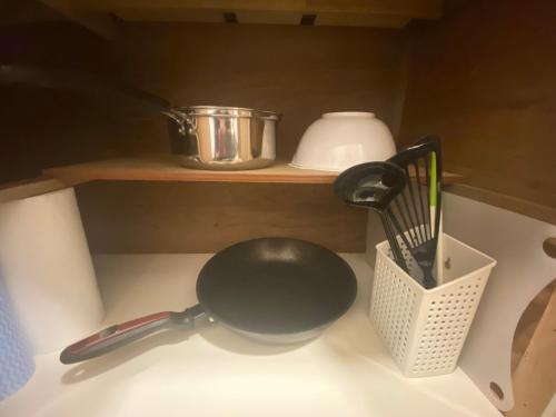 a kitchen counter with a frying pan and utensils at ラ・ポート空港前107 in Shime