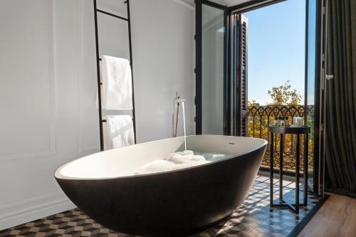 a bath tub in a bathroom with a balcony at Serras Barcelona in Barcelona