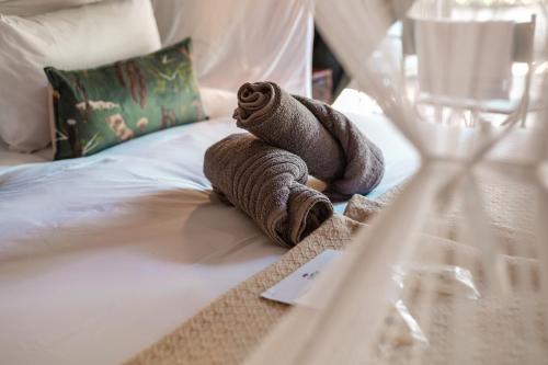 a towel animal sitting on top of a bed at Umkumbe Bush Lodge - Luxury Tented Camp in Sabi Sand Game Reserve