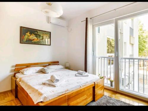a bedroom with a bed and a large window at Apartman Borislava in Trebinje
