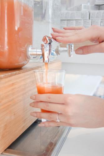 a woman is holding a glass of orange juice at Novotel Monte-Carlo in Monte Carlo