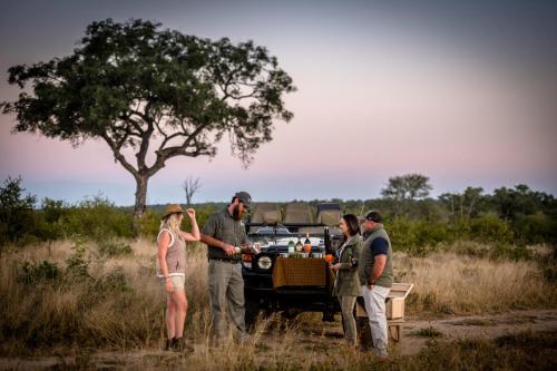 a group of people standing in front of a truck at Umkumbe Bush Lodge - Luxury Tented Camp in Sabi Sand Game Reserve