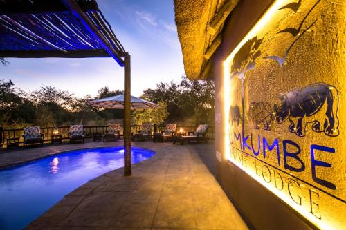 a wall with a mural of a rhino next to a pool at Umkumbe Bush Lodge - Luxury Tented Camp in Sabi Sand Game Reserve