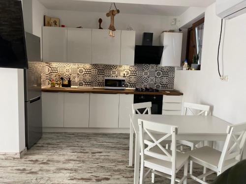 a kitchen with white cabinets and a table and chairs at Casa Maria in 2 Mai