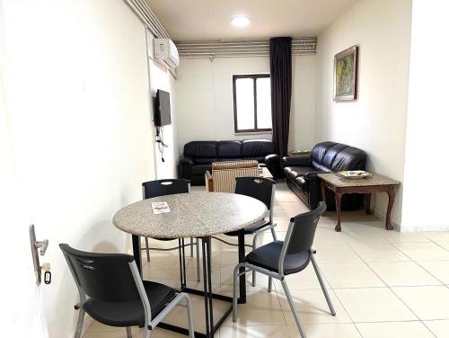 a waiting room with a table and chairs and a couch at Al Qatal Building in Al Qasţal