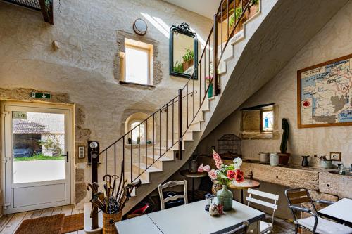 a living room with a staircase and a table at Le Domaine des Carriers in Chevroches