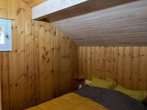 ein Schlafzimmer mit Holzwänden und einem Bett darin in der Unterkunft Maglines in Vars