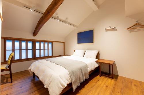 a bedroom with a large bed and a table at MACHIYA HOTEL madoka - Vacation STAY 65847v in Izumo