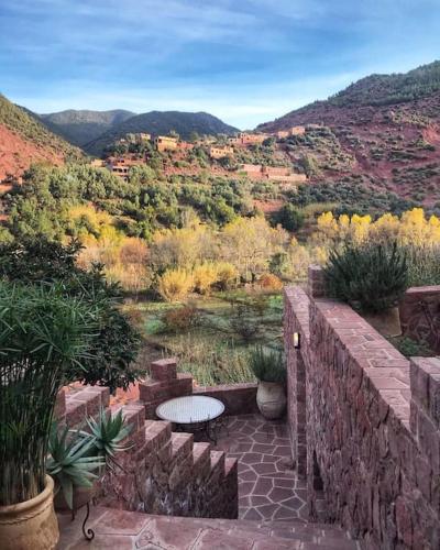 a patio with a table and a view of the mountains at Boutique Guesthouse Dar Zohra in Marrakech