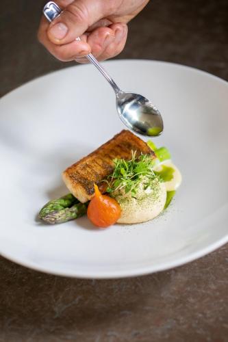 a person eating a plate of food with a spoon at Färna Herrgård & Spa in Färna