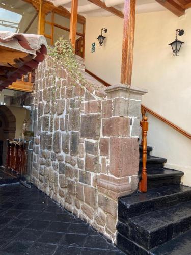 a stone wall with stairs in a building at Hotel Midori in Cusco
