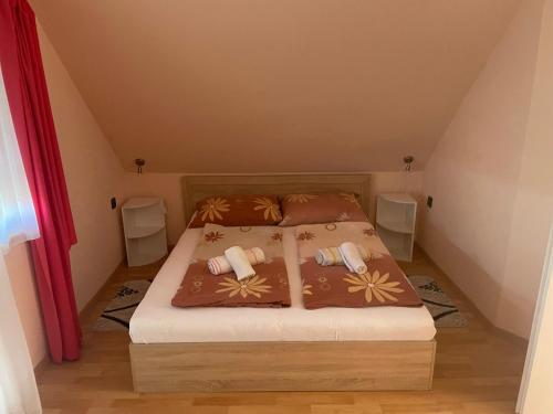 a bedroom with a bed with two pillows on it at Gitta Apartmanház in Zalakaros