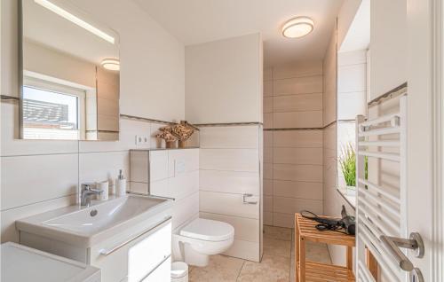 La salle de bains blanche est pourvue de toilettes et d'un lavabo. dans l'établissement Nice Home In Langenhorn With Wifi, à Langenhorn